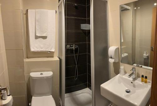 奧波里尼奧的住宿－博覽會旅館，浴室配有卫生间、盥洗盆和淋浴。
