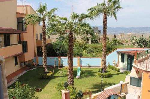 uitzicht op een tuin met palmbomen bij Villa Terry in Catona