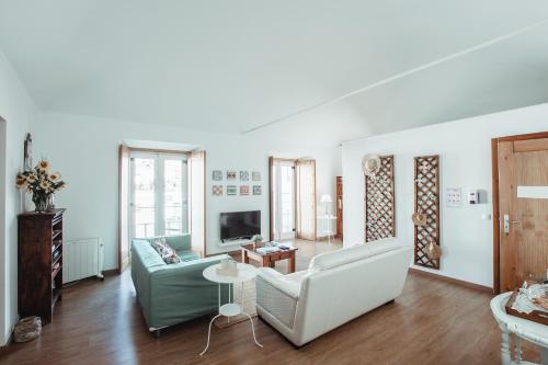 a living room with a couch and a tv at Segredo d'Alecrim in Fronteira