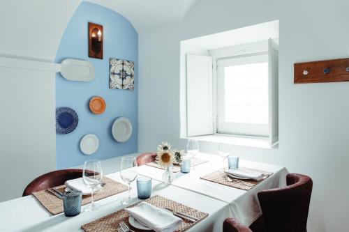a dining room with a white table and chairs at Segredo d'Alecrim in Fronteira