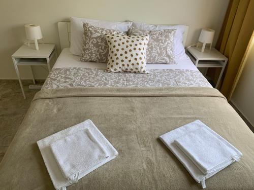 a large bed with two white towels on it at Lux House Olga in Ruma