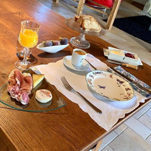 a table with a plate of food and a glass of orange juice at L'ère du temps in Cuzance