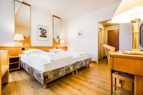 um quarto de hotel com uma cama e uma secretária em Taste Hotel Dresden-ehemals Residenz Alt Dresden em Dresden