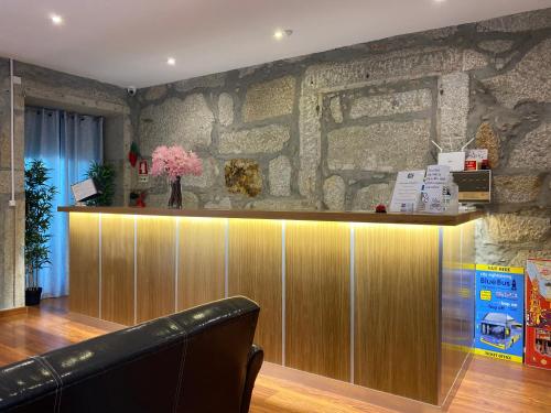 a bar in a room with a stone wall at Hotel Porto Rico in Porto