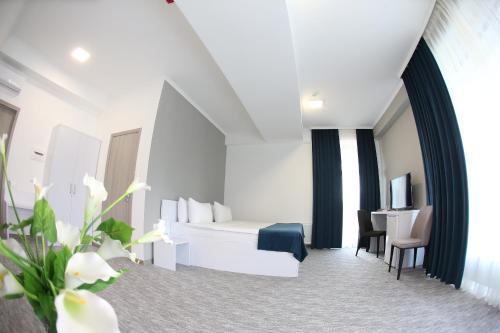 a hotel room with a bed and a desk at Glass Cube Hotel in Chişinău