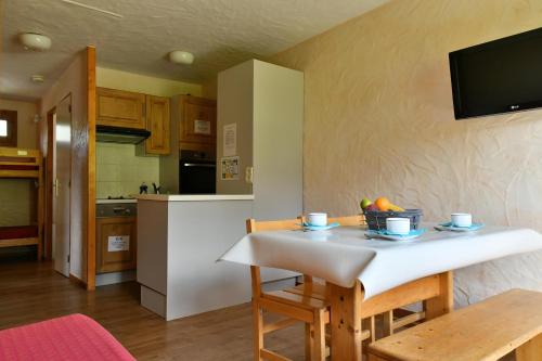 - une cuisine et une salle à manger avec une table et un bol de fruits dans l'établissement Chalet Le Grand Cap, à Tignes
