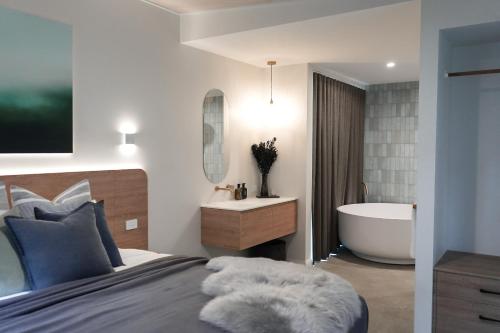 a bedroom with a bed and a bath tub at Melo Studios in Dunsborough