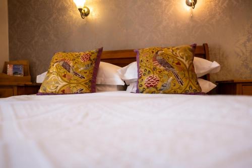 a bedroom with a bed with two pillows at Ty Mawr Country Hotel & Restaurant in Carmarthen