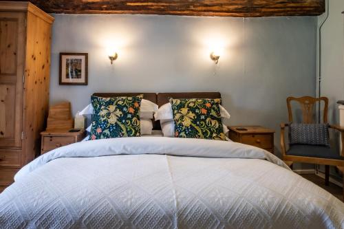 a bedroom with a bed and a chair at Ty Mawr Country Hotel in Carmarthen