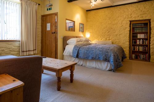 a bedroom with a bed and a book shelf at Ty Mawr Country Hotel & Restaurant in Carmarthen