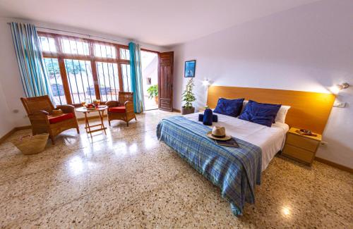 um quarto com uma cama, uma mesa e cadeiras em Villa Punta Negra HEATED POOL tenerifesummervillas em Puerto de Santiago