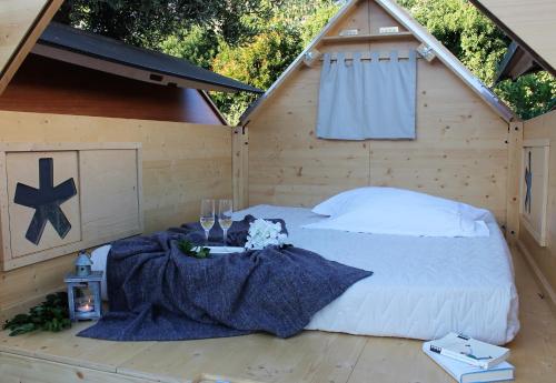 Cama en una cabaña de madera con techo en Residence Felice, en Celle Ligure