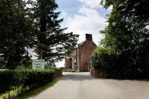 a house with a sign on the side of a road at Cressfield Country House Hotel in Ecclefechan
