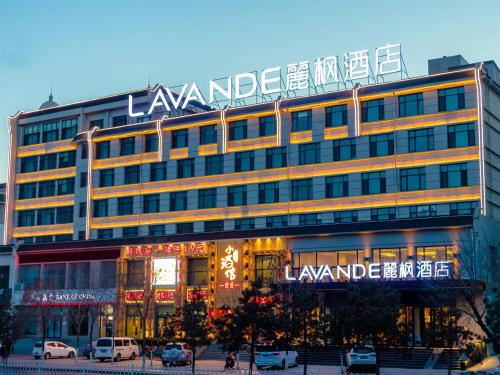 un gran edificio con un cartel encima en Lavande Hotel Qiqihar Supervisory Office en Qiqihar