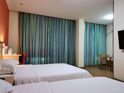 a hotel room with two beds and a window at 7Days Inn Yongzhou Central Hospital in Yongzhou