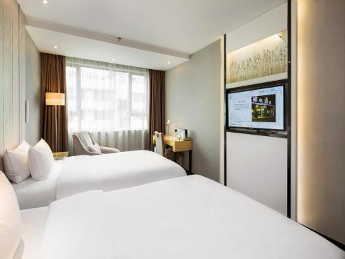 a hotel room with two beds and a flat screen tv at Lavande Hotel Hengyang Changsheng West Road Nanhua University in Hengyang