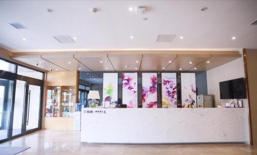 a lobby with a counter with pink flowers on the windows at Lavande Hotel (Changchun Yiqi Branch) in Changchun