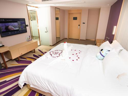 a bedroom with a white bed with a teddy bear on it at Lavande Hotel Zhoushan Putuo in Zhoushan