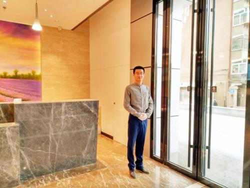 a man standing in front of a window at Lavande Hotel Jinan Second Ring East Road Quanfu Overpass Branch in Jinan
