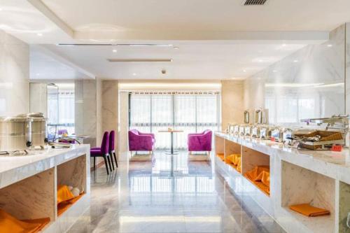 a large kitchen with purple chairs in a room at Lavande Hotel (Gaozhou Xiantai Bridge Branch) in Maoming