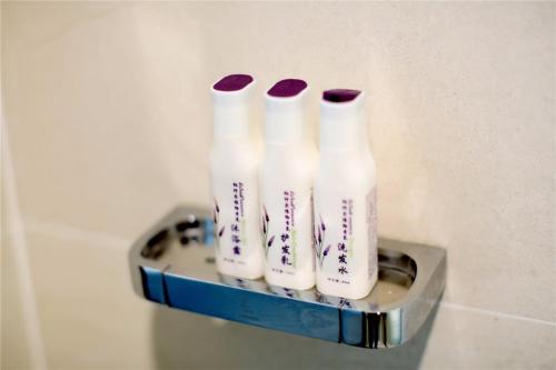 a group of four milk bottles sitting on a shelf at Lavande Hotel Rizhao Rong'an Square Wanda Movie Theater Branch in Rizhao