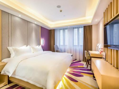 a hotel room with a large bed and a desk at Lavande Hotel Langfang City Government in Langfang