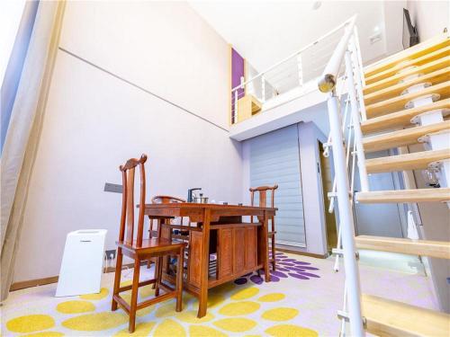 Habitación con mesa, sillas y escaleras. en Lavande Hotel(Nanchang Qingshan Road Subway Station Branch), en Nanchang