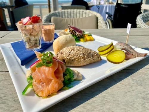 a plate of food with salmon and other foods on a table at Mevira Appartement in Zandvoort