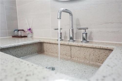 a kitchen counter with a sink with a faucet at Lavande Hotel Shijiazhuang Zhonghua North Street Zhongchu Plaza Branch in Shijiazhuang
