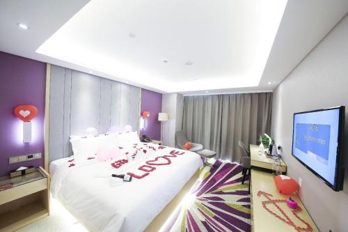 a bedroom with a large bed and a flat screen tv at Lavande Hotel (Harbin Ice and Snow World University of Commerce Branch) in Harbin