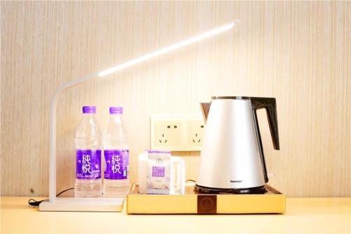 a blender sitting on a counter with bottles of water at Lavande Hotel Shijiazhuang Zhonghua North Street Zhongchu Plaza Branch in Shijiazhuang