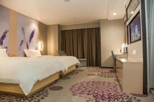 um quarto de hotel com uma cama grande e um lavatório em Lavande Hotels Xianning Tonghui Square Branch em Xianning