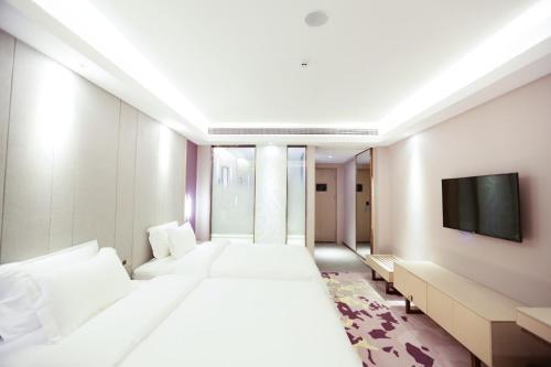um quarto de hotel com duas camas e uma televisão de ecrã plano em Lavande Hotel (Jingdezhen Taoxichuan Creative Square Branch) em Jingdezhen