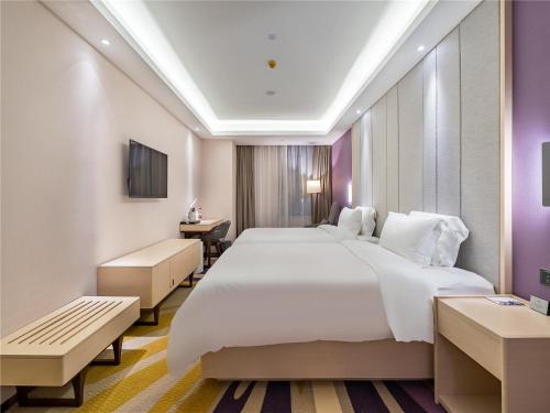 Pokój hotelowy z dużym łóżkiem i biurkiem w obiekcie Lavande Hotel Xuzhou Junsheng Plaza w mieście Xuzhou