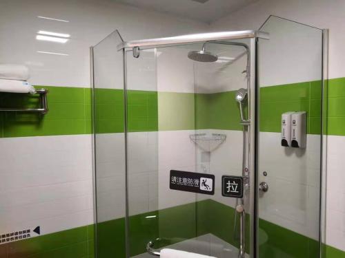 a bathroom with a shower with green and white stripes at 7Days Inn Yongzhou Central Hospital in Yongzhou