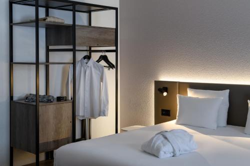 a bedroom with a bed and a clothes rack at Novotel Zurich City West in Zürich