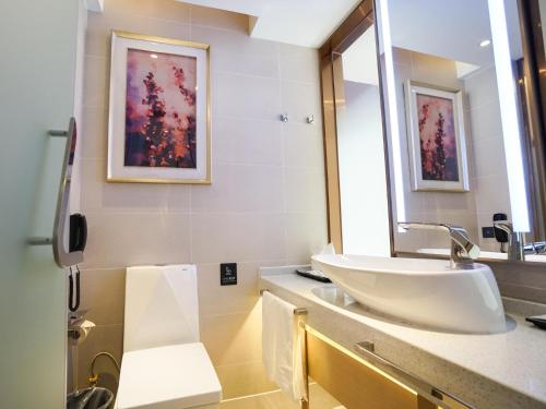 y baño con lavabo y espejo. en Lavande Hotel Jingmen Planet World City, en Jingmen
