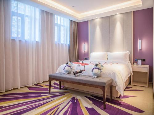 Lavande Hotel Cangzhou Kaiyuan Avenue Rongsheng Plaza في Cangzhou: غرفة نوم مع سرير مع اثنين من الحيوانات المحشوة عليه