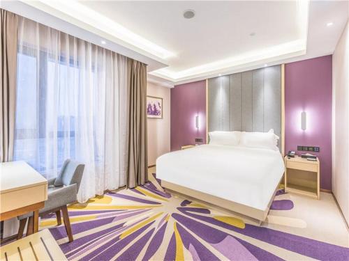 Lavande Hotel Langfang Dacheng Xinda Xintiandi Plaza في Daicheng: غرفة في الفندق مع سرير أبيض كبير ومكتب