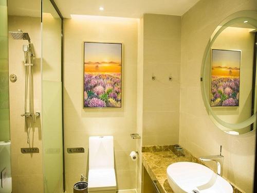 La salle de bains est pourvue d'un lavabo, de toilettes et d'un miroir. dans l'établissement Lavande Hotel Sihong Bus Terminal Zhongyuan Logistics City Branch, à Sihong