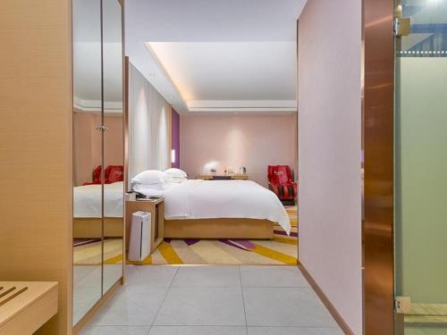 a hotel room with a bed and a mirror at Lavande Hotel (Guangzhou North Railway Station Branch) in Huadu