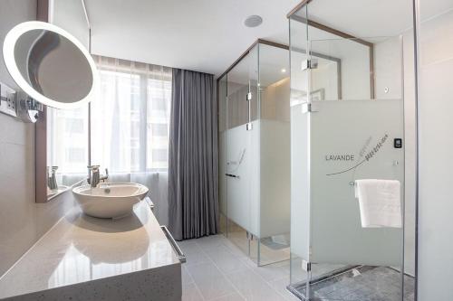 y baño con lavabo y ducha acristalada. en Lavande Hotel (Nanchang Liantang Xiaolan Industrial Park Branch), en Nanchang