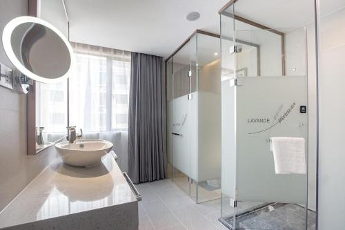une salle de bain avec un lavabo et une douche en verre dans l'établissement Lavande Hotel (Nanchang Liantang Xiaolan Industrial Park Branch), à Nanchang