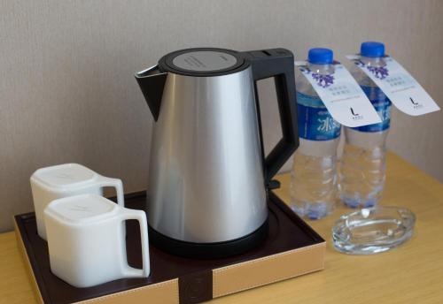 a coffee maker and two bottles of water on a table at Lavande Hotel Chaozhou Plaza Branch in Chaozhou