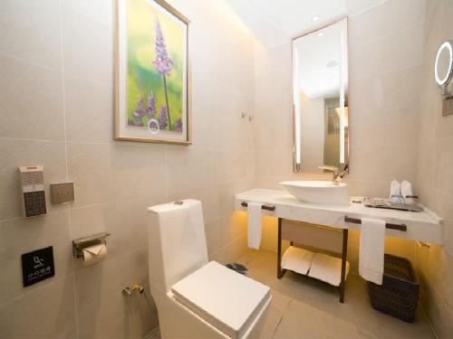 a white bathroom with a sink and a toilet at Lavande Hotel (Guangzhou North Railway Station Branch) in Huadu
