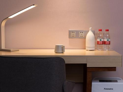 a desk with two bottles of water and a lamp at Lavande Hotel Yangchun Donghu in Yangjiang
