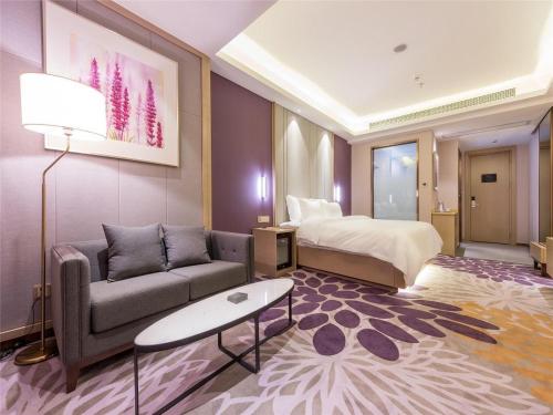 a hotel room with a couch and a bed at Lavande Hotel (Fuzhou Wanda Branch) in Fuzhou