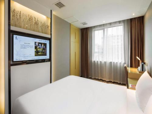 a hotel room with a bed and a television at Lavande Hotel Hengyang Changsheng West Road Nanhua University in Hengyang