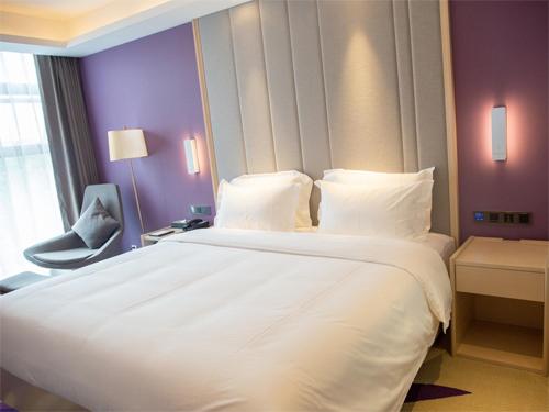 a large white bed in a hotel room at Lavande Hotel Enshi Cultural Center in Enshi