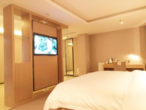 a bedroom with a bed and a television in it at Lavande Hotel Jinan Second Ring East Road Quanfu Overpass Branch in Jinan